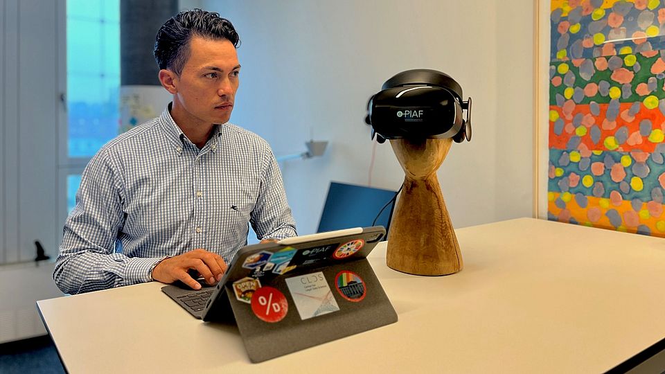 Apollo Dauag am Stehpult, neben sich iPad und VR-Brille.